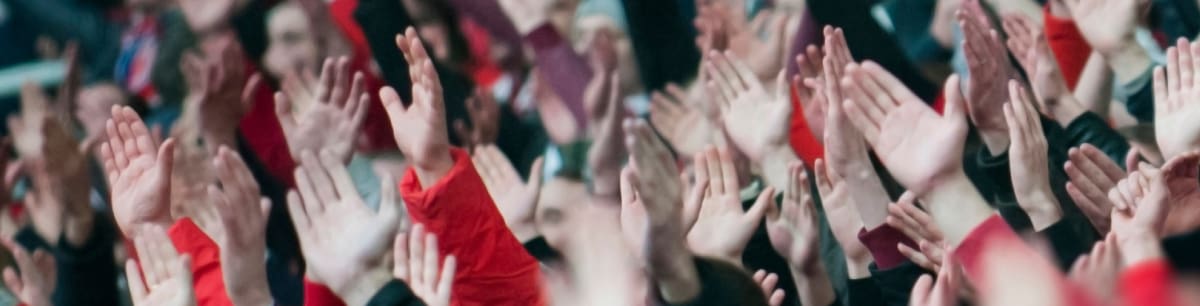 A football event crowd with their hands in the air clapping