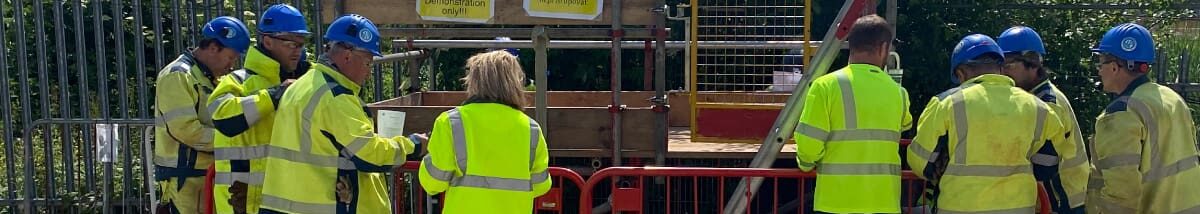 Slovakian contractors needing help with interpreting. Contractor in a group listening to the female interpreter.